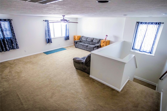 living room featuring carpet flooring, a textured ceiling, and ceiling fan