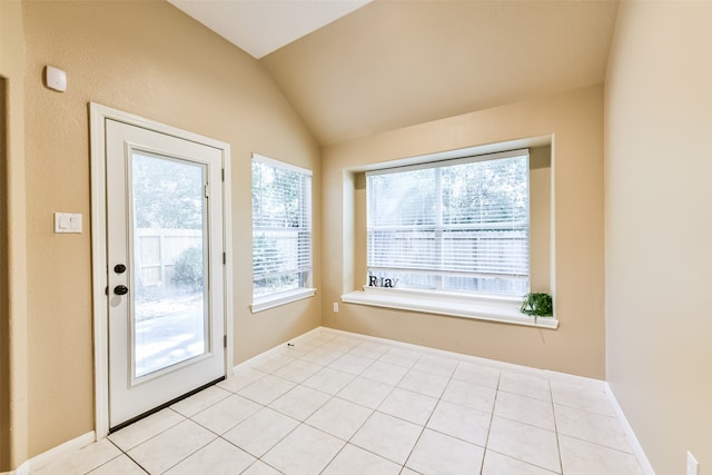 entryway with light tile patterned floors and vaulted ceiling