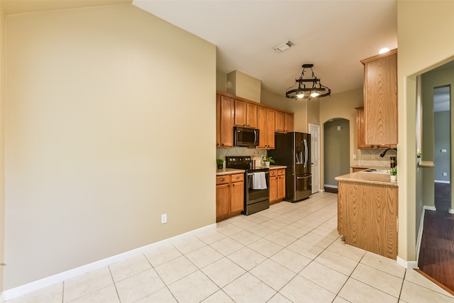 kitchen featuring tasteful backsplash, appliances with stainless steel finishes, decorative light fixtures, and light tile patterned floors