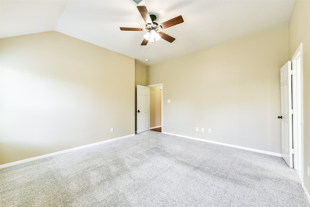 empty room featuring ceiling fan, vaulted ceiling, and carpet floors