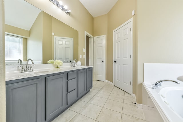 bathroom featuring tile patterned flooring, vanity, a tub to relax in, and lofted ceiling