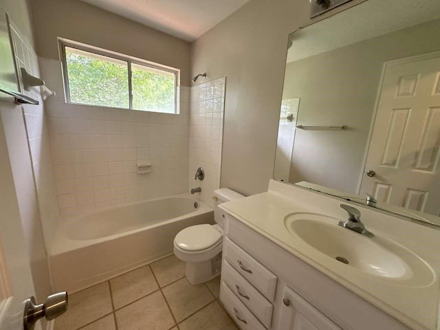 full bathroom with tile patterned flooring, vanity, tiled shower / bath combo, and toilet