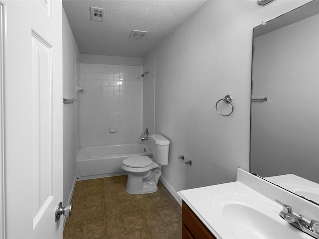 full bathroom featuring a textured ceiling, toilet, vanity, and tiled shower / bath