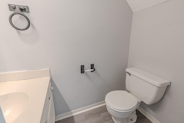 bathroom featuring hardwood / wood-style flooring, a textured ceiling, toilet, and vanity