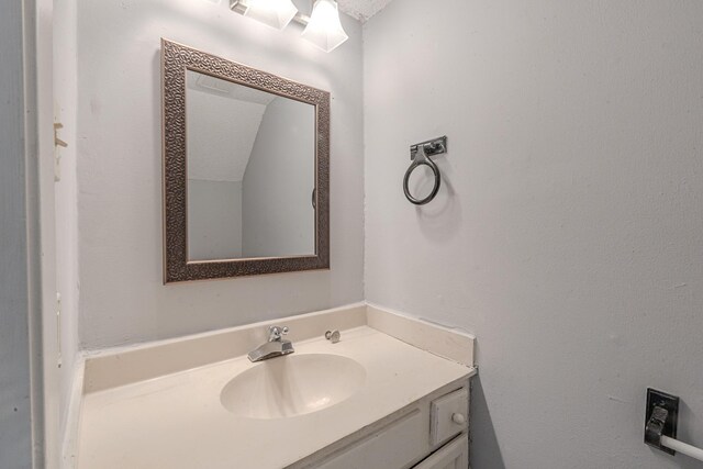 bathroom with a textured ceiling and vanity