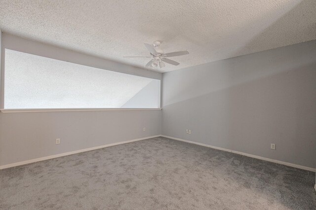 carpeted empty room featuring ceiling fan, a textured ceiling, and vaulted ceiling