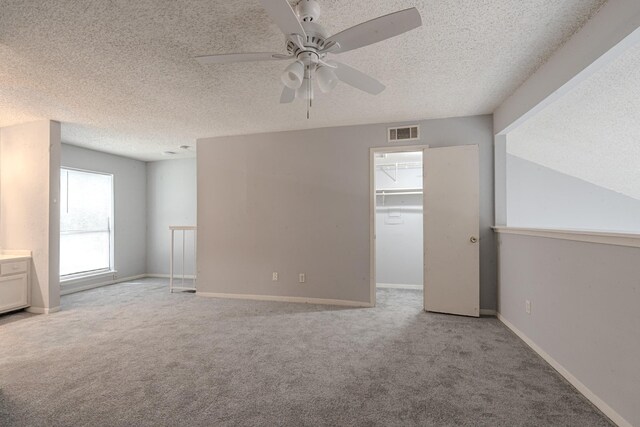 spare room featuring ceiling fan, light colored carpet, and plenty of natural light