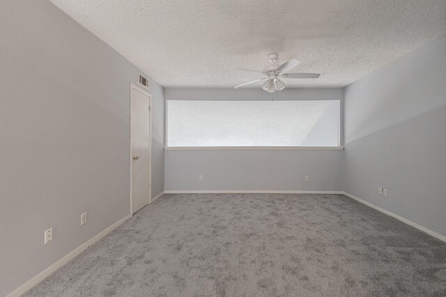 unfurnished room with ceiling fan, a textured ceiling, and carpet