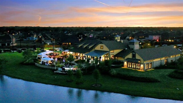 aerial view at dusk featuring a water view