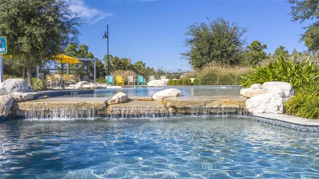 view of swimming pool with pool water feature