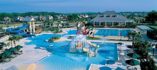 view of swimming pool with a water slide and a patio