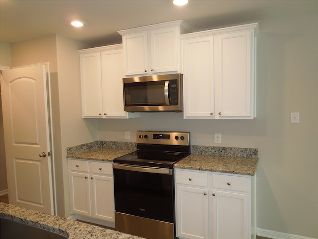 kitchen featuring white cabinetry, light stone countertops, and stainless steel appliances