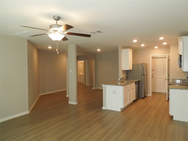 kitchen featuring white cabinetry, hardwood / wood-style flooring, light stone counters, and ceiling fan