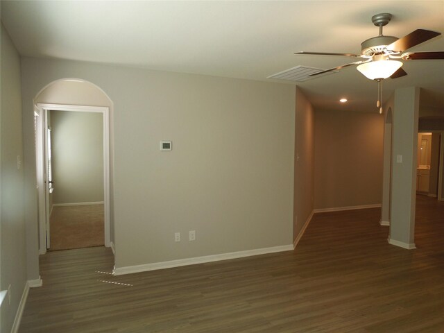 empty room featuring ceiling fan and dark wood-type flooring