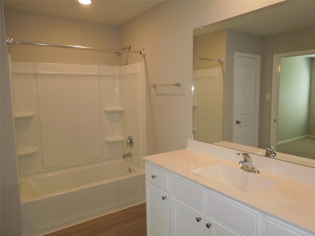 bathroom featuring hardwood / wood-style flooring, vanity, and  shower combination