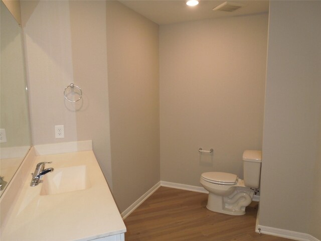 bathroom featuring vanity, hardwood / wood-style flooring, and toilet