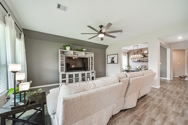 living room featuring ceiling fan and hardwood / wood-style flooring