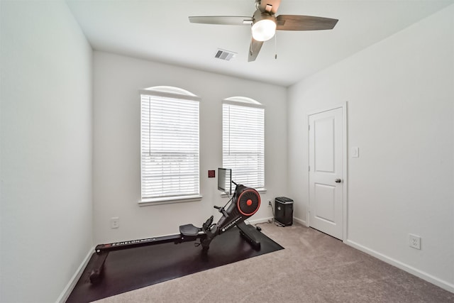 exercise room with ceiling fan and light colored carpet