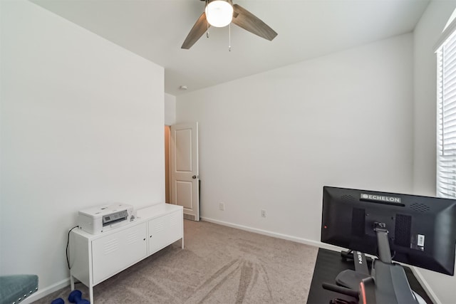 office space featuring ceiling fan and light carpet