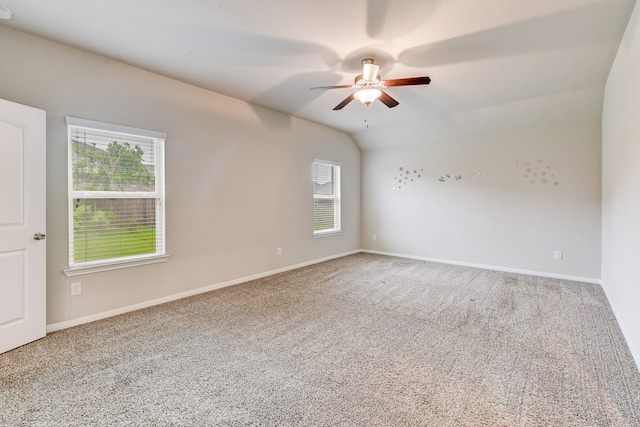 carpeted spare room with ceiling fan, lofted ceiling, and a healthy amount of sunlight