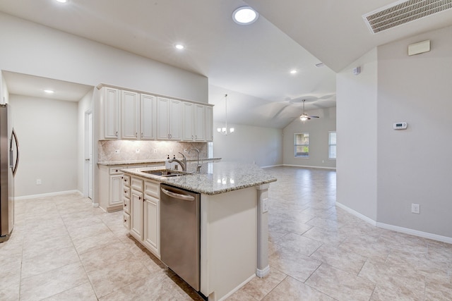 kitchen featuring sink, backsplash, light stone counters, stainless steel appliances, and a center island with sink