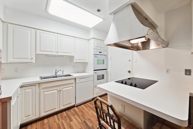 kitchen with white appliances, sink, light hardwood / wood-style floors, island exhaust hood, and white cabinetry