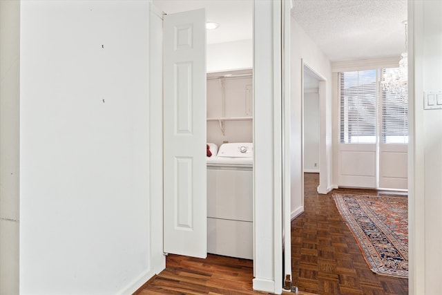 hall featuring separate washer and dryer, a textured ceiling, and dark parquet floors