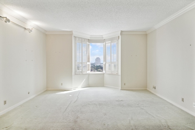 unfurnished room featuring light carpet, crown molding, and a textured ceiling