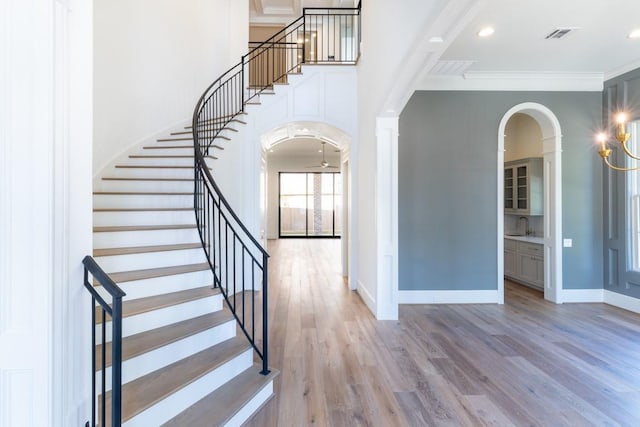 foyer with ornamental molding and hardwood / wood-style flooring