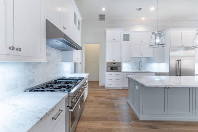 kitchen featuring white cabinetry, light stone countertops, and premium appliances