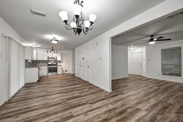 kitchen with ceiling fan with notable chandelier, white cabinets, stainless steel appliances, and dark hardwood / wood-style floors