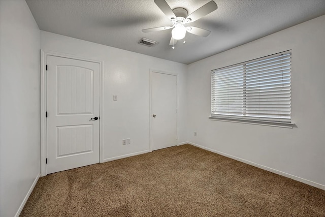 unfurnished bedroom featuring carpet floors, a textured ceiling, and ceiling fan