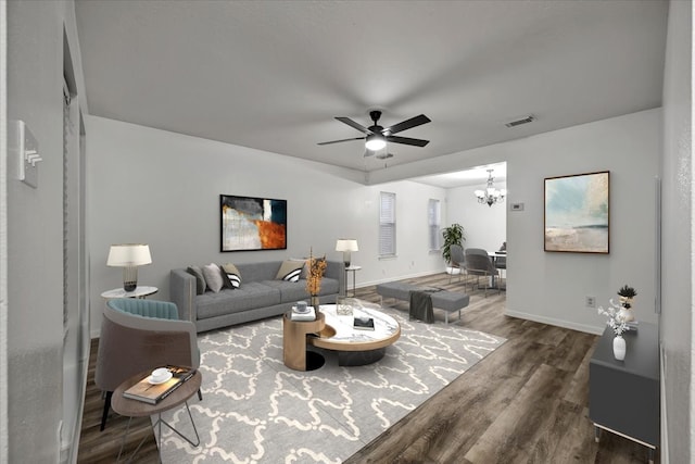 living room with ceiling fan with notable chandelier and hardwood / wood-style floors