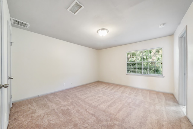 spare room featuring light colored carpet