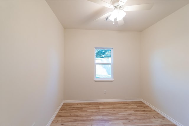 spare room with ceiling fan, light wood-style flooring, and baseboards