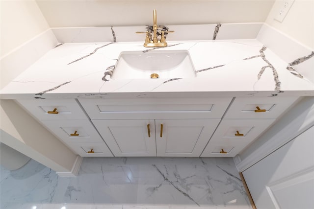 bathroom with marble finish floor and a sink