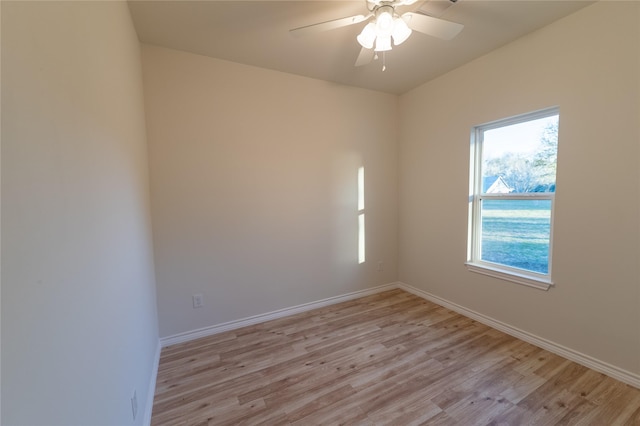 spare room with light wood-type flooring, ceiling fan, and baseboards