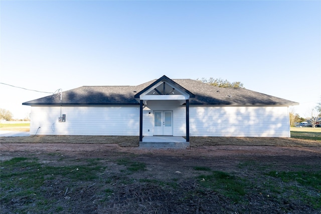 view of front of house with roof with shingles and french doors