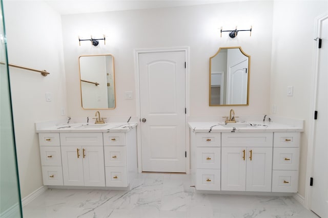 bathroom featuring marble finish floor, two vanities, and a sink