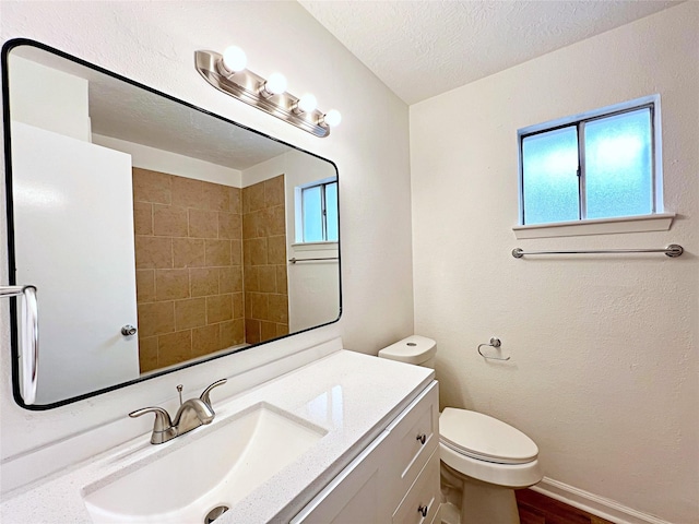 bathroom with vanity, a textured ceiling, and toilet