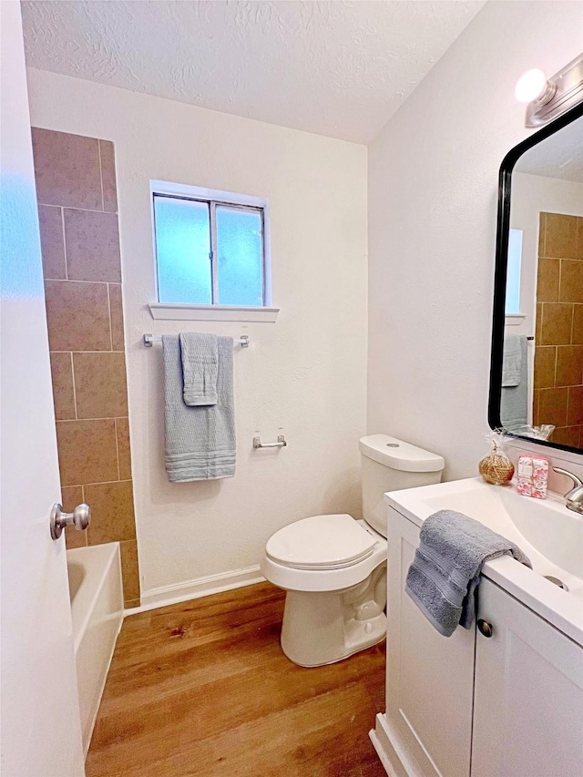 full bathroom with hardwood / wood-style flooring, vanity, a textured ceiling, and toilet