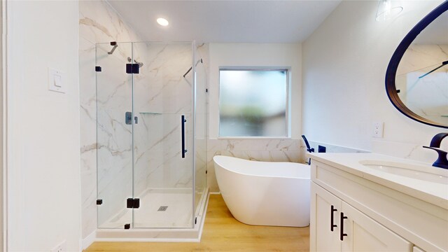 bathroom with a shower with door, vanity, and wood-type flooring