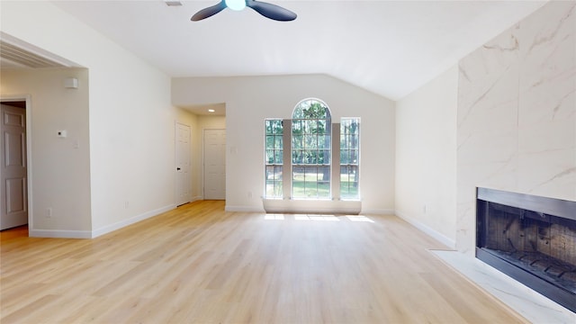 unfurnished living room with plenty of natural light, a high end fireplace, and light hardwood / wood-style flooring