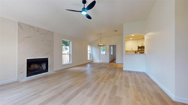 unfurnished living room featuring light hardwood / wood-style floors, a fireplace, lofted ceiling, and ceiling fan