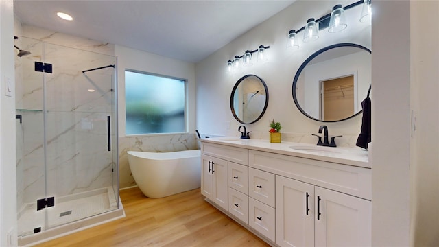 bathroom with hardwood / wood-style flooring, shower with separate bathtub, and dual bowl vanity