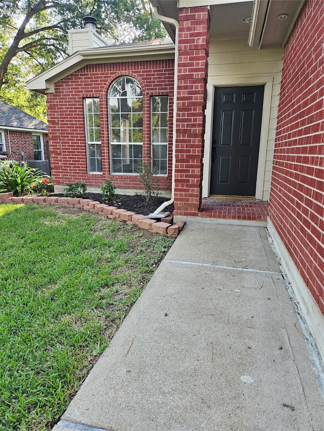 doorway to property with a lawn