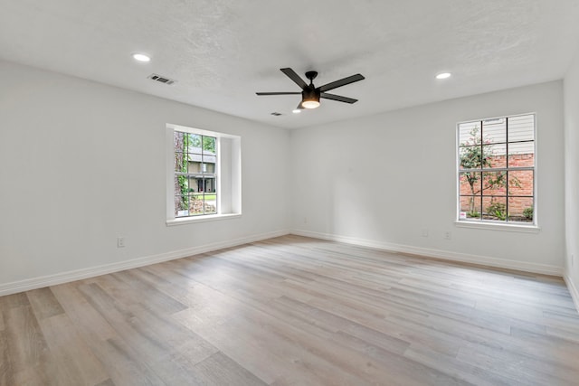 unfurnished room featuring ceiling fan, a textured ceiling, and light wood-type flooring