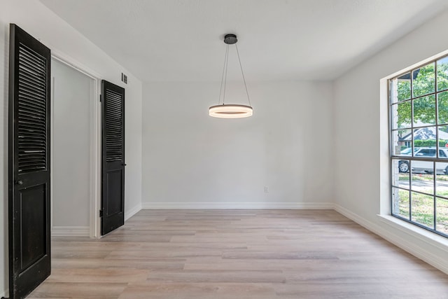 unfurnished dining area featuring a healthy amount of sunlight and light wood-type flooring