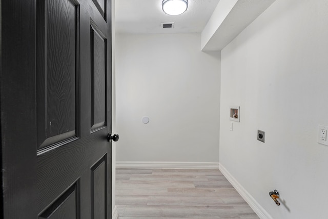 laundry area featuring hookup for a washing machine, light hardwood / wood-style floors, and hookup for an electric dryer