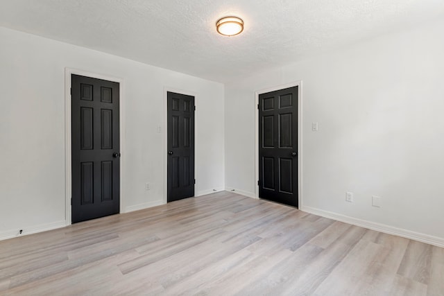 spare room with light hardwood / wood-style flooring and a textured ceiling